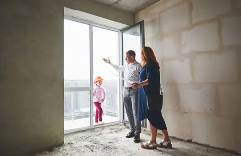 Ingénieure présentant des plans à son client pour rénovation: priorités techniques, budget, matériaux, agencement, chantier maîtrisé.