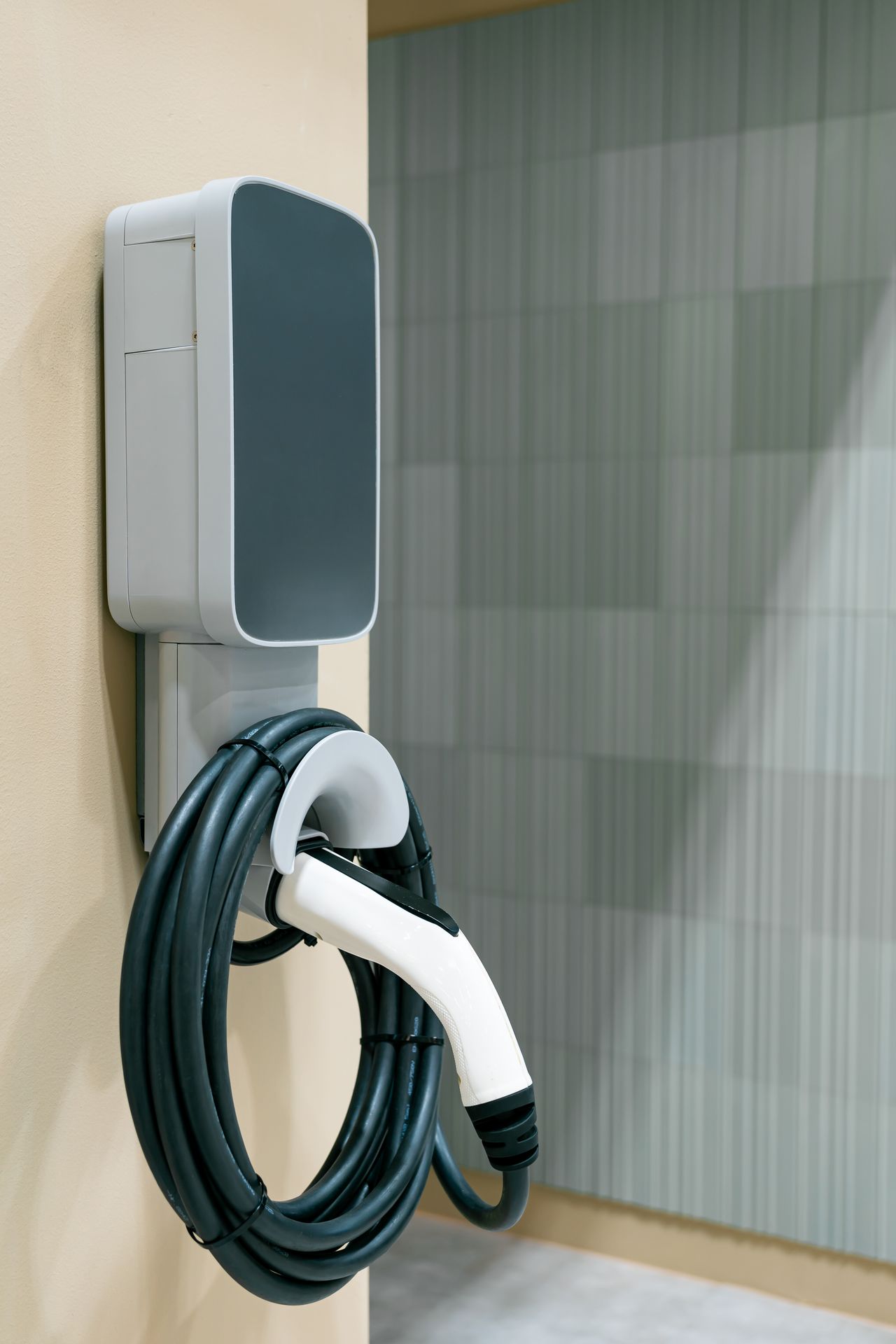 Borne de recharge murale pour voiture électrique installée dans un garage de maison individuelle.