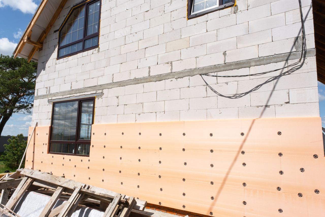 Chantier de maison durable avec mur en bois, isolant biosourcé et béton bas carbone.