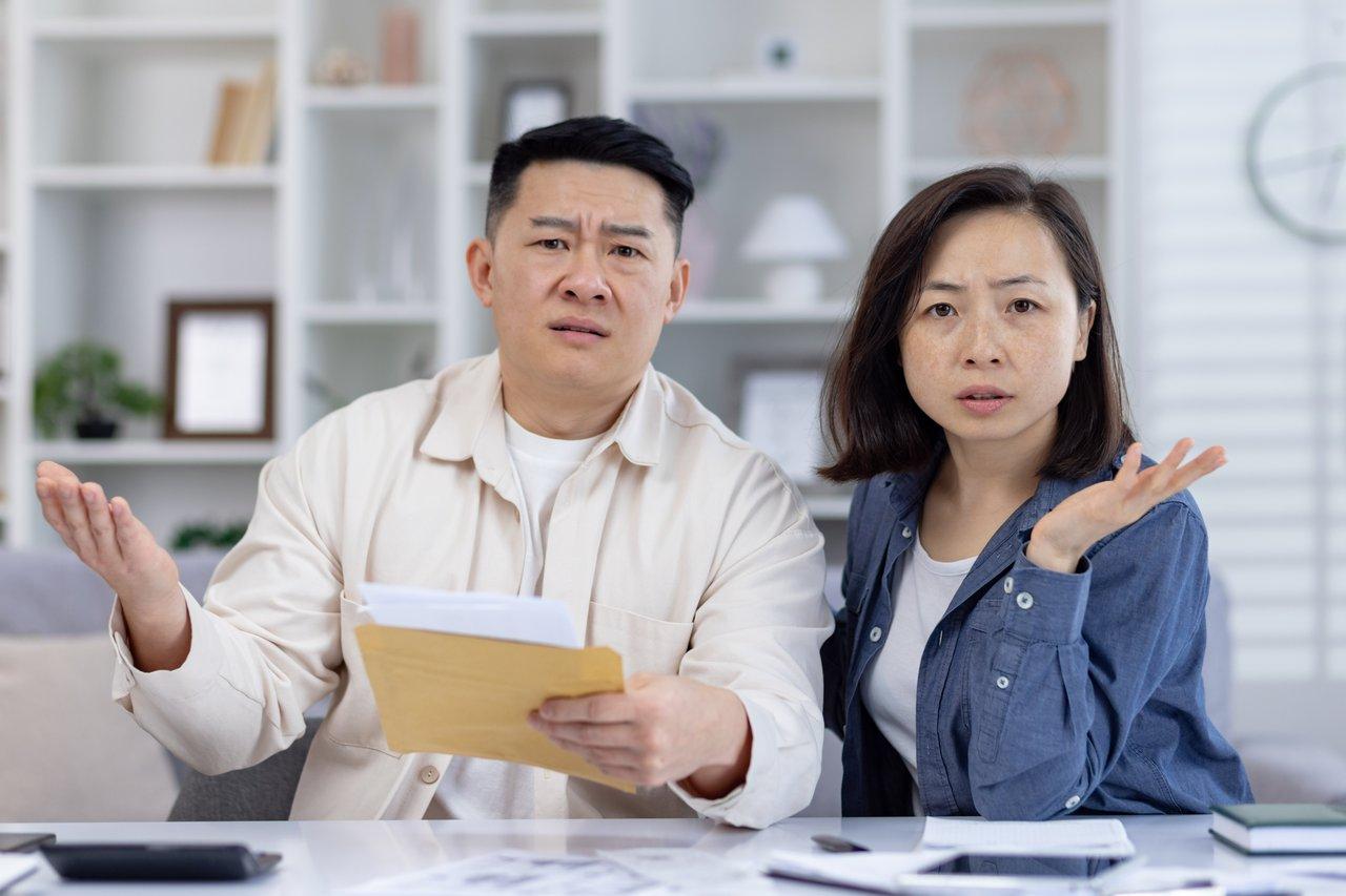 Couple préparant des documents légaux avant la signature chez le notaire pour leur achat immobilier.