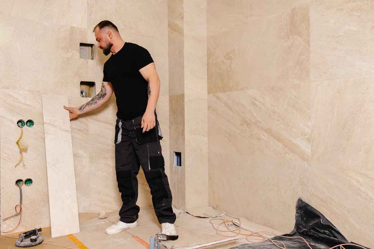 Installation de papier peint vinyle dans une salle de bain moderne, mur préparé pour une décoration élégante.