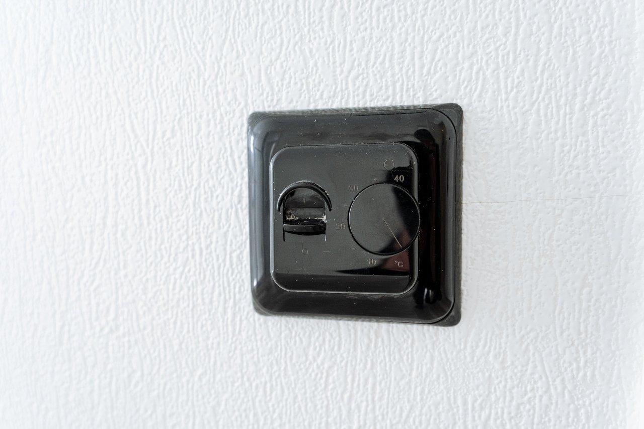 Installation électrique d'un interrupteur noir sur mur blanc pour un système va-et-vient efficace et facile.