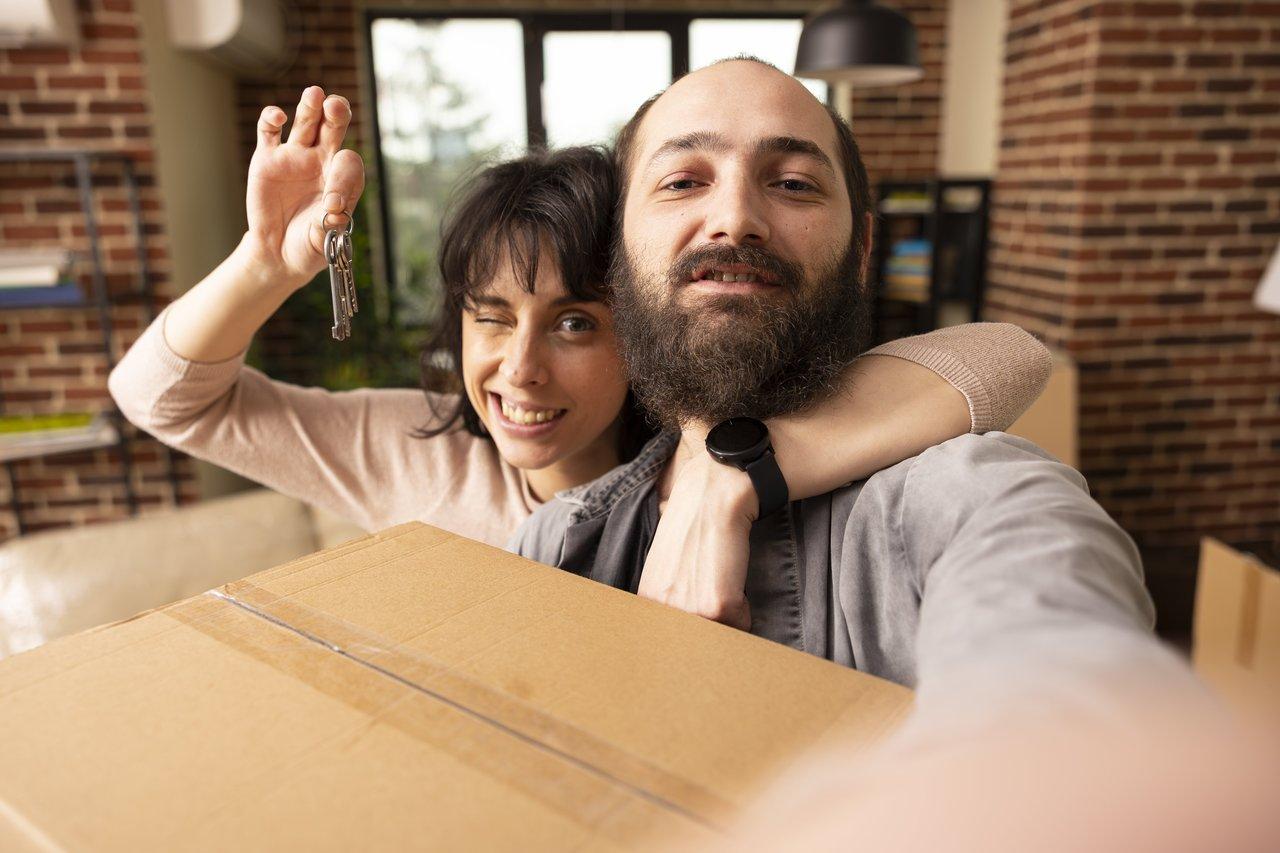 Jeune couple heureux bénéficiant des aides de l’État pour primo-accédants en 2025 lors de leur déménagement.