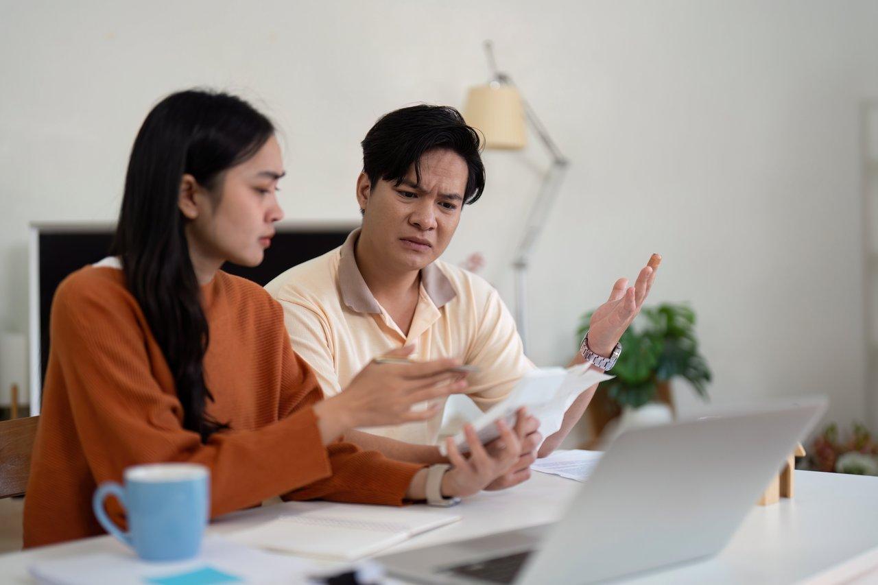 Jeune couple lors d'une réunion avec un courtier d'assurance emprunteur pour choisir la meilleure couverture.