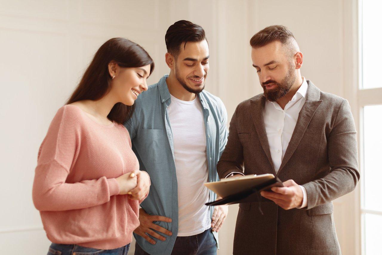Jeune couple rencontrant un courtier en crédit immobilier pour discuter d'un achat avec un faible apport en 2025.