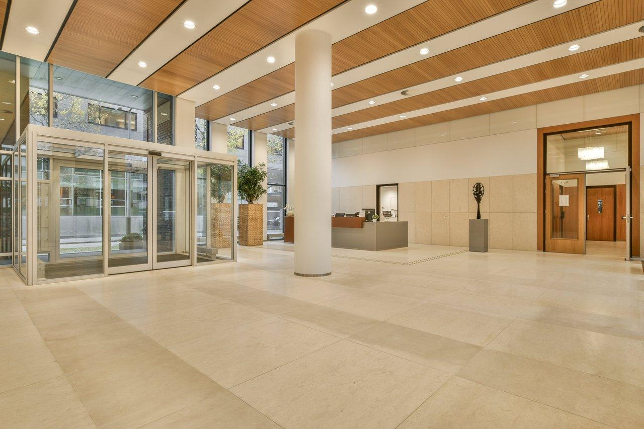 Lobby moderne d’un appartement T3 dans une résidence récente, équipé d’un ascenseur et d’espaces verts soignés.