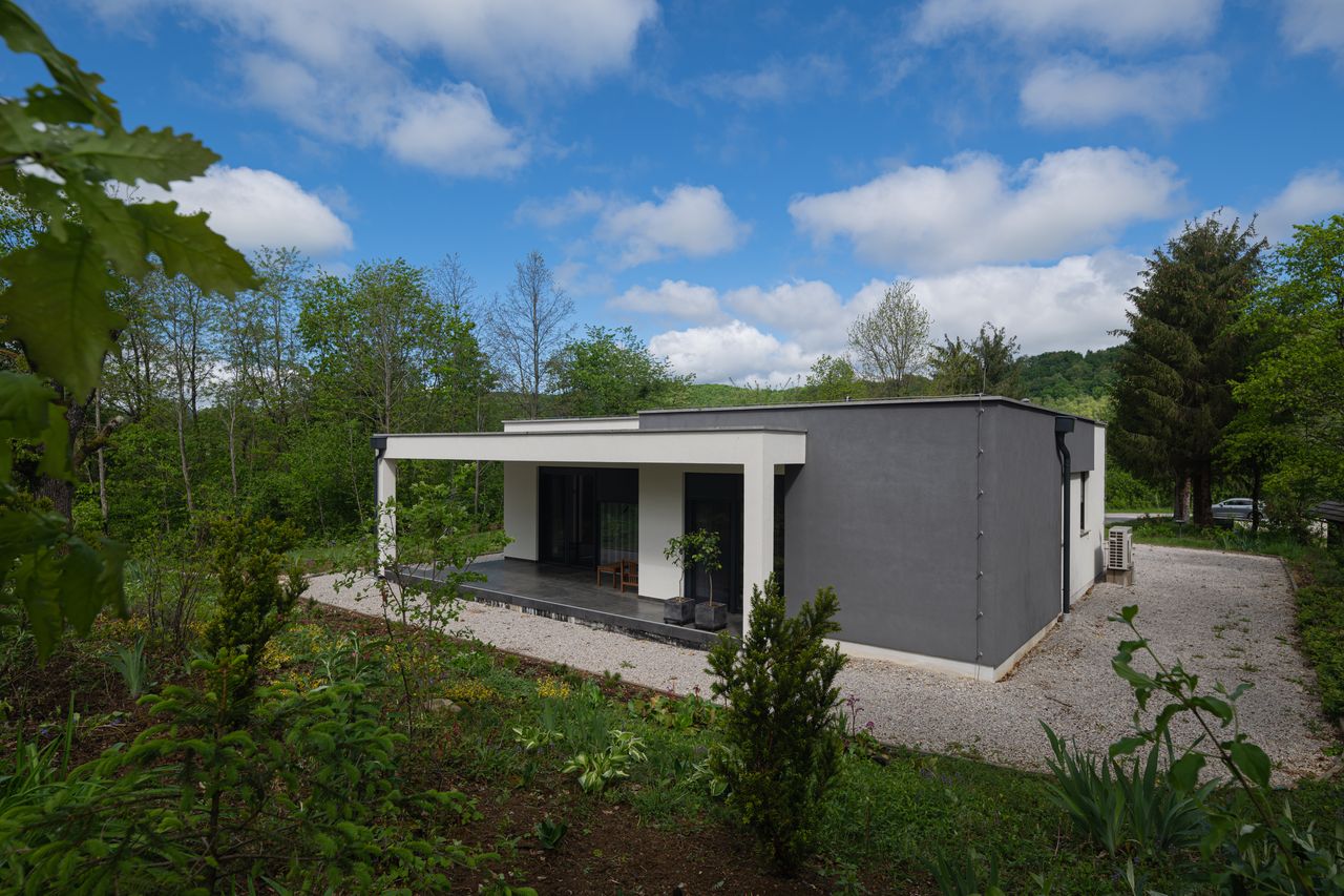 Maison neuve en campagne avec coffret de raccordement électrique en limite de propriété et toiture solaire.