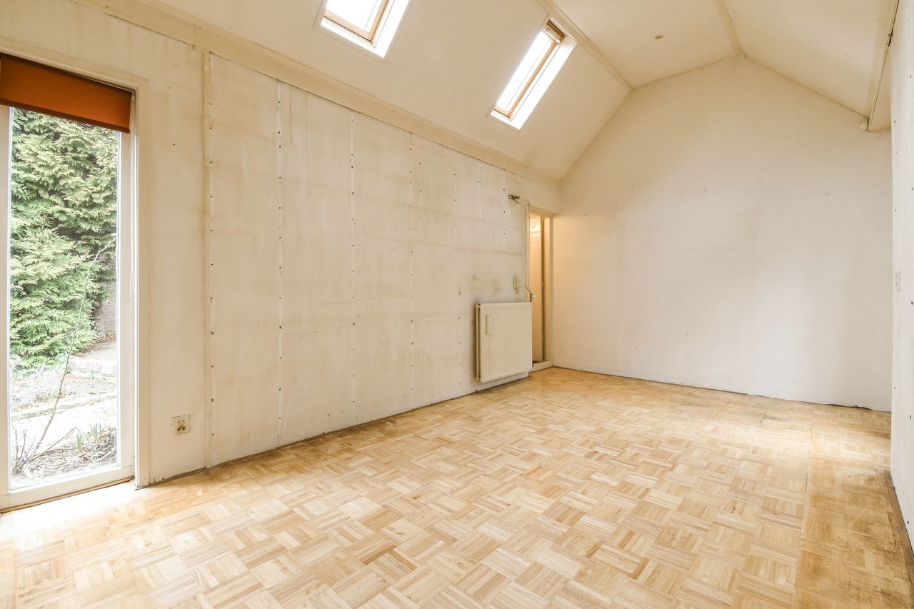 Pièce vide lumineuse avec parquet bois, puits de lumière et ambiance sobre de maison neuve.