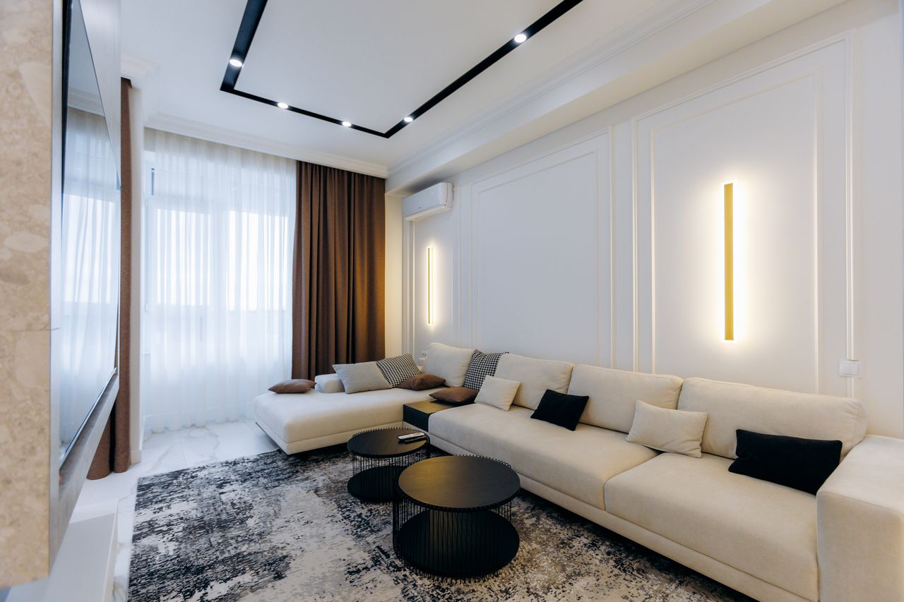 Salon lumineux avec thermostat mural, radiateurs modernes et ampoules LED dans une maison familiale élégante.