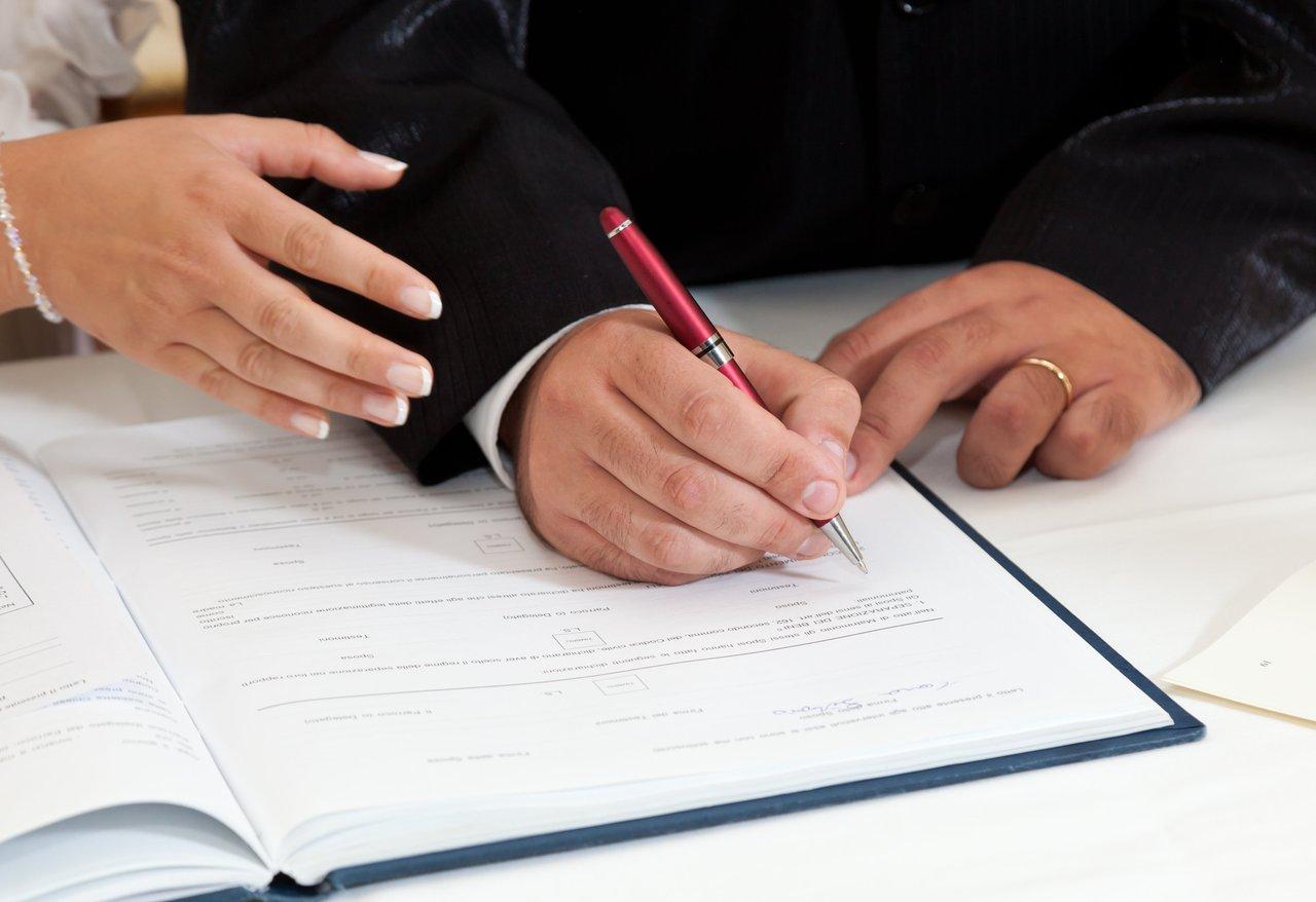 Signature de l'acte notarié par un couple lors de leur achat immobilier, étape essentielle de la réussite.