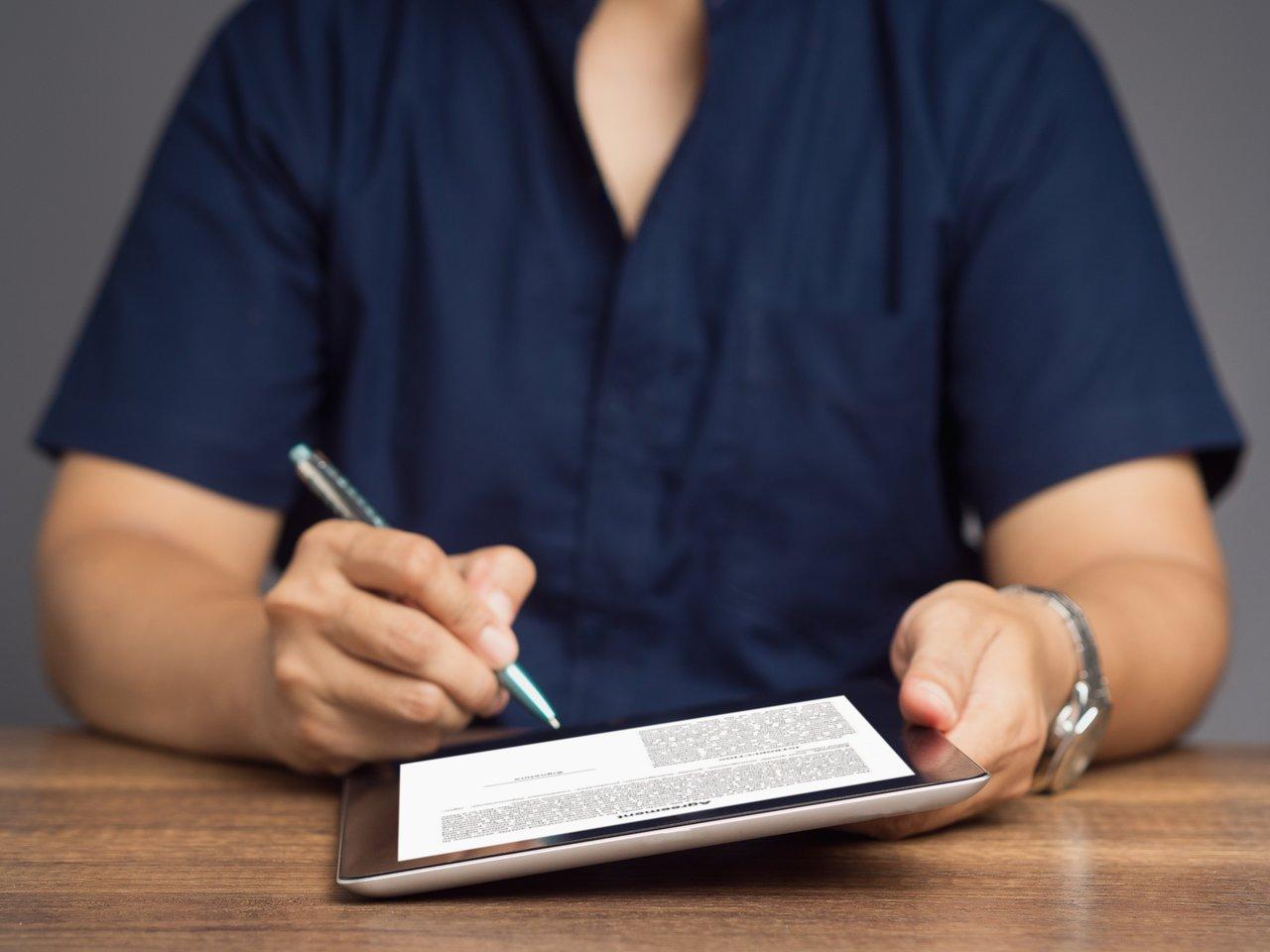 Signature électronique sécurisée sur tablette pour finaliser un compromis de vente immobilier en toute confiance.