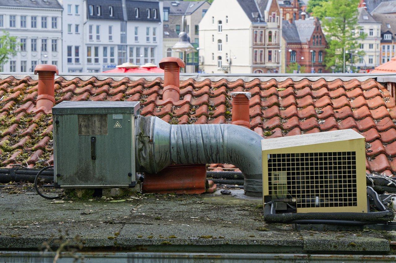 Tableau comparatif des systèmes de ventilation adaptés selon l'isolation et le type de logement, illustré par une unité de ventilation en toiture.