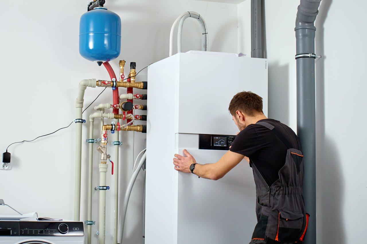 Technicien certifié RGE installant une pompe à chaleur air-eau pour un chauffage efficace dans une maison.