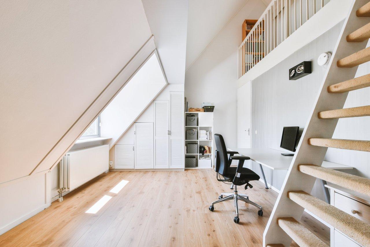 Un bureau sur mesure sous un escalier, optimisant un espace inutilisé avec rangements intégrés.
