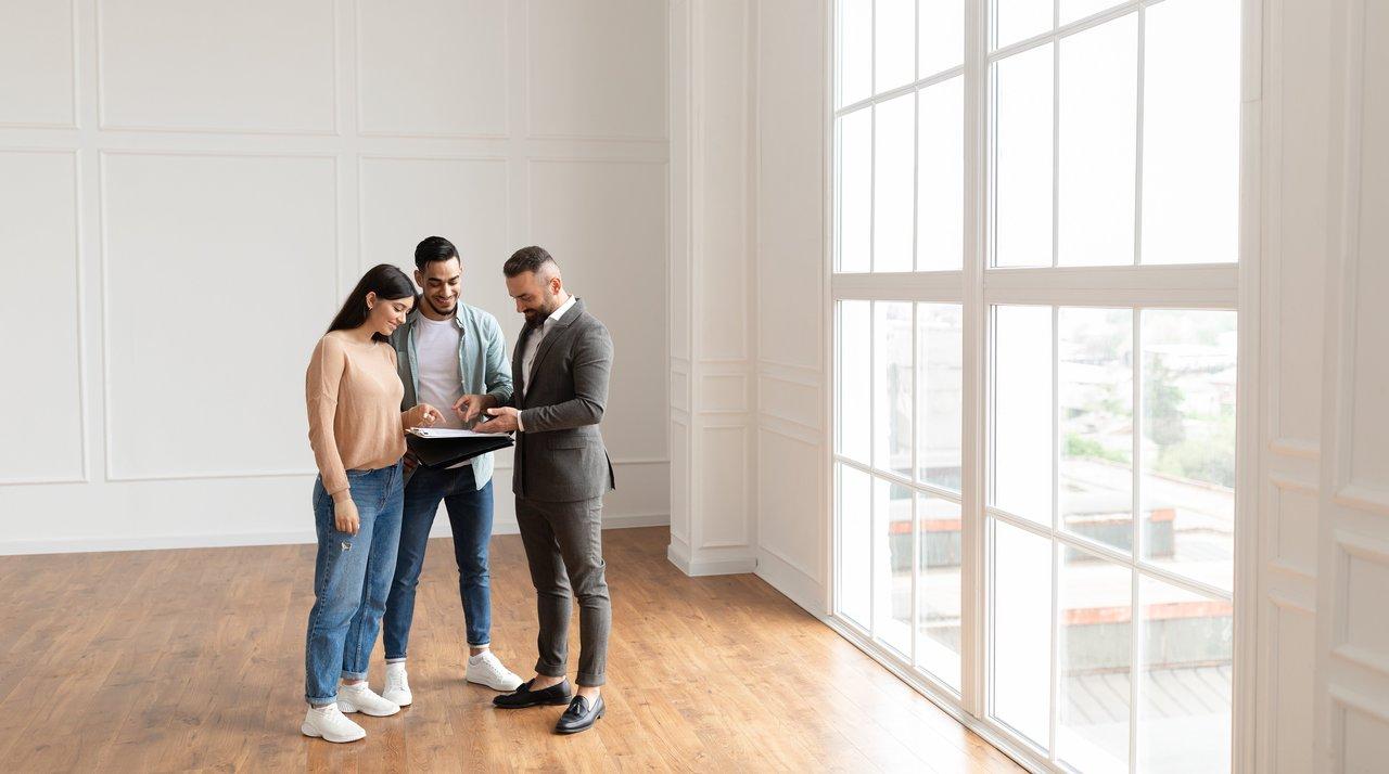 Un jeune couple en consultation immobilière pour profiter des offres de lancement en location-accession.
