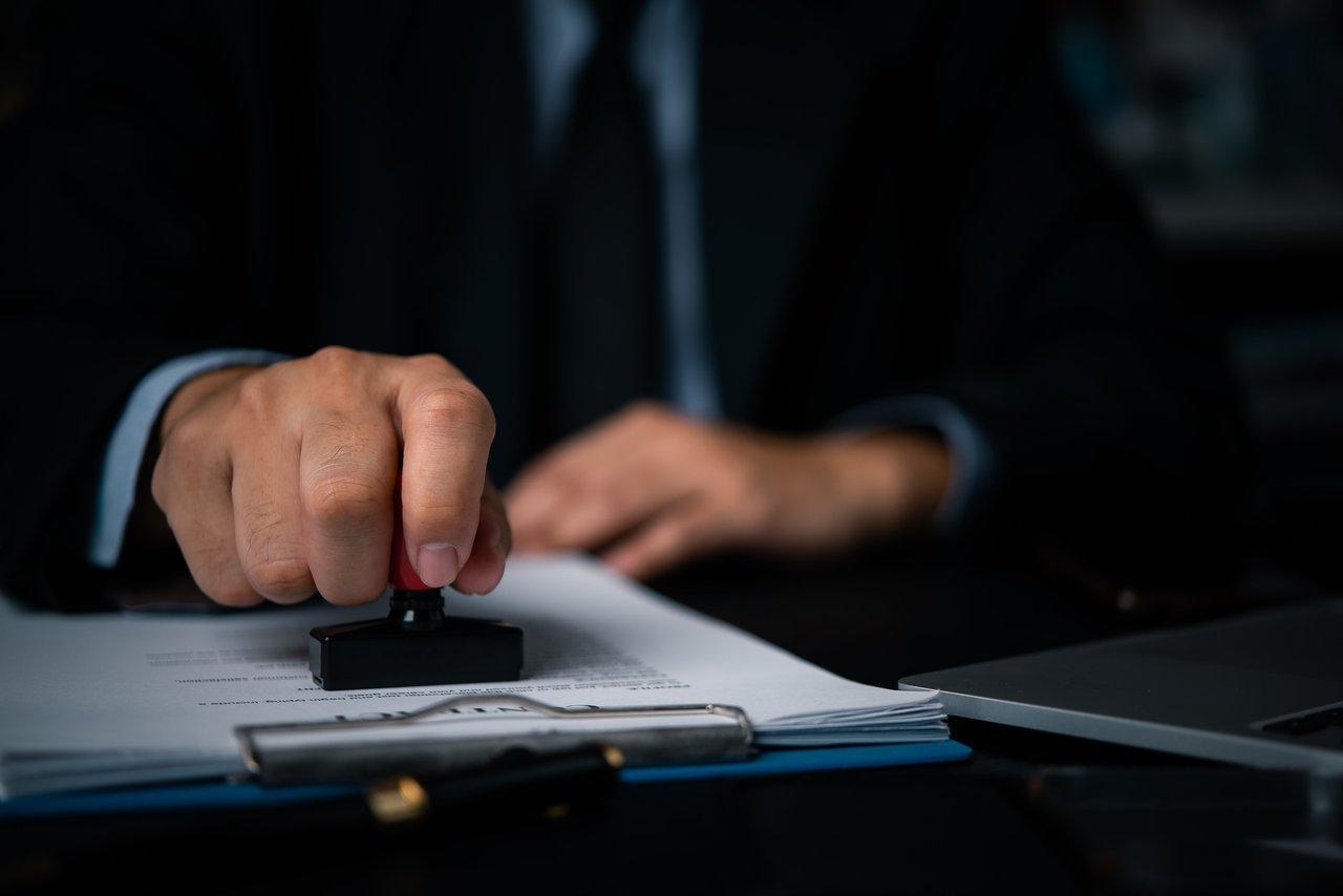 Un notaire examinant des documents officiels pour garantir la sécurité juridique du déblocage des fonds immobiliers.