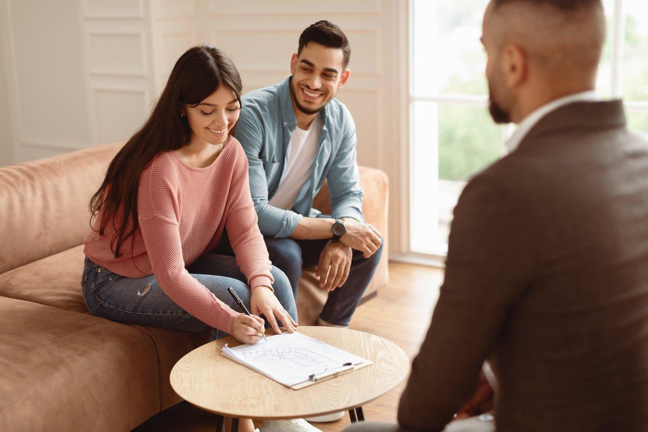 Une réunion avec un courtier immobilier pour optimiser le reste à vivre d'une famille lors d'un achat immobilier.