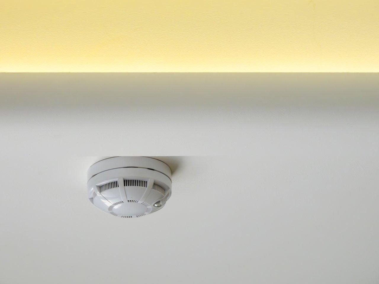 Une sélection de smart smoke detectors modernes présentée sur une table, compatibles installation standard française.