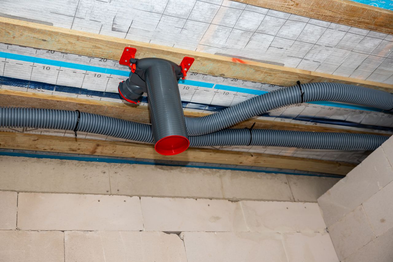 VMC double flux dans une maison individuelle avec caisson central, gaines et bouches de ventilation visibles.