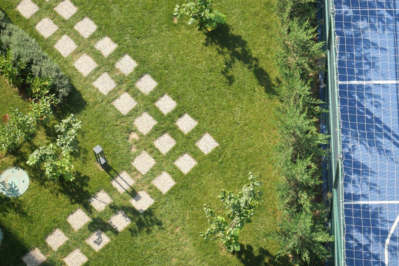 Vue aérienne d’un jardin privatif avec abri, illustrant l’impact fiscal et administratif en 2026.