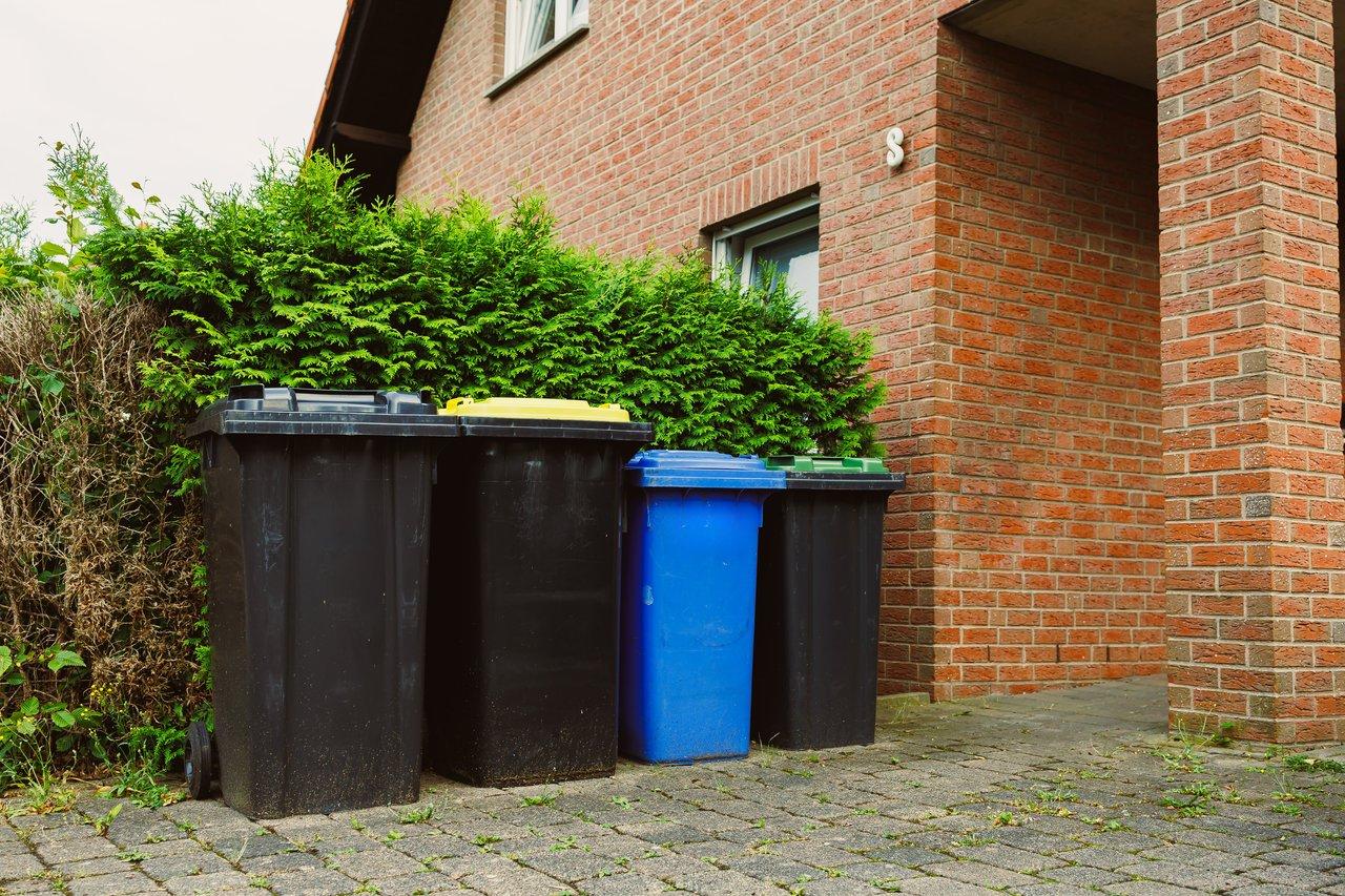 Vue extérieure d’une maison de 100 m² avec une poubelle de tri pour une gestion efficace des déchets.